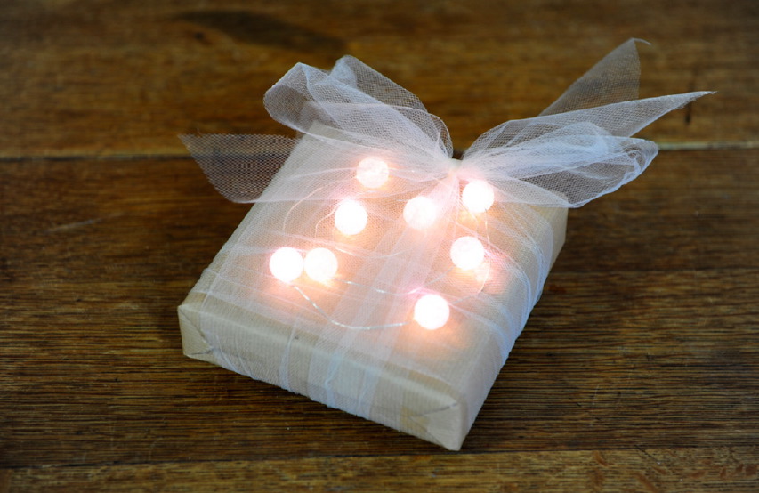 Pacchetto di Natale con carta da pacchi grezza e palline luminose